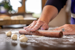 mini rolling pin rolling out dumplings with one hand