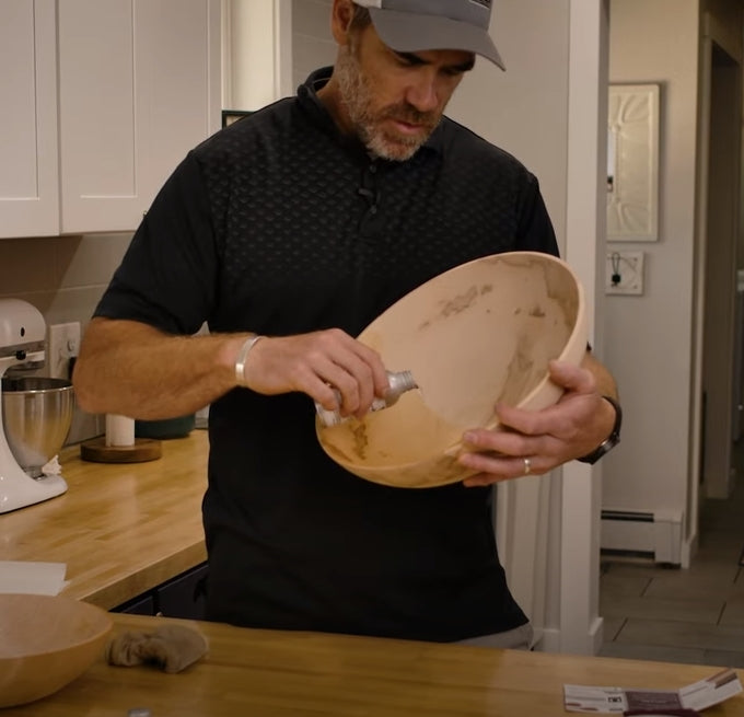 Pouring oil into a dry wooden bowl