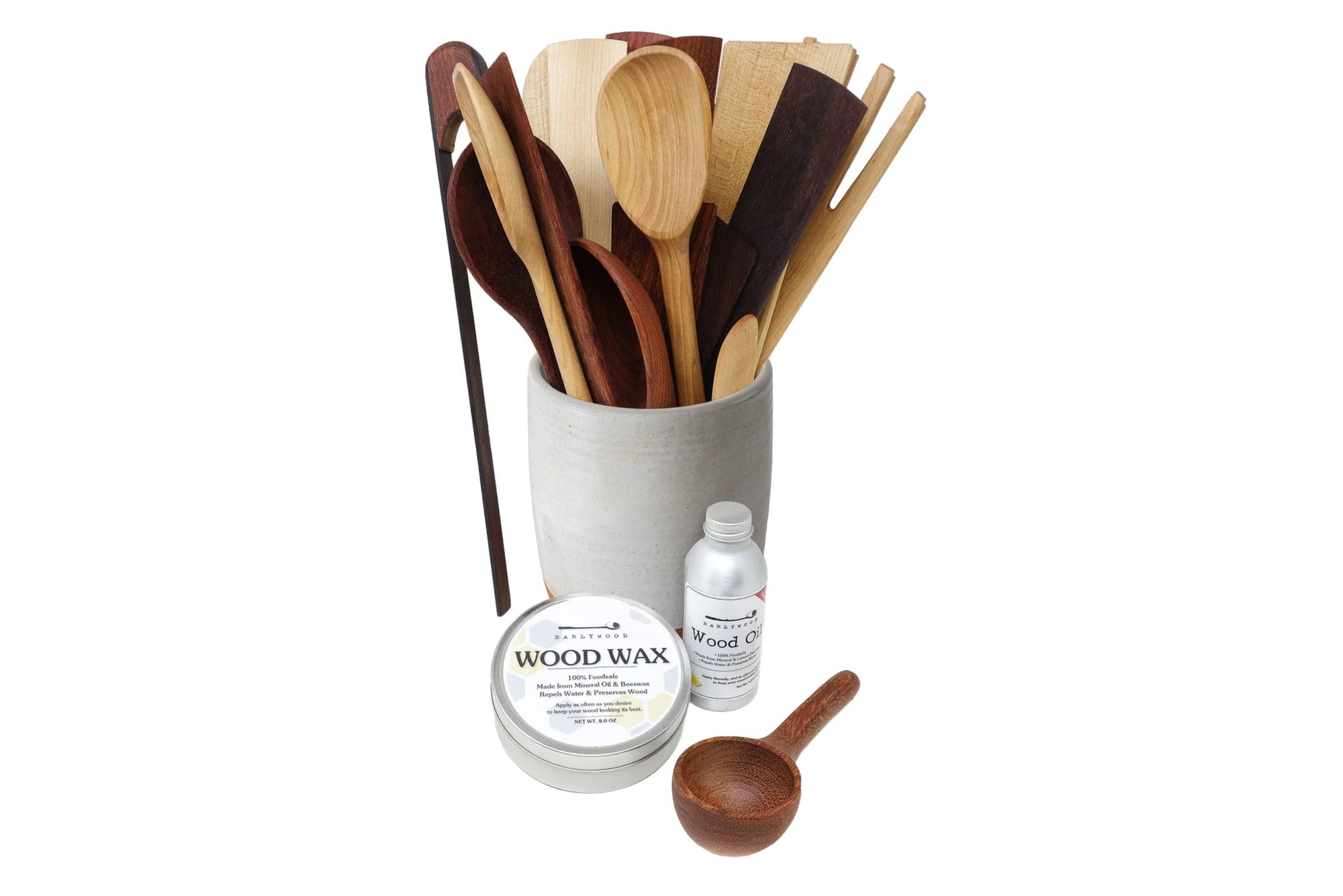Set of wooden utensils in a container with wood care products on a white background