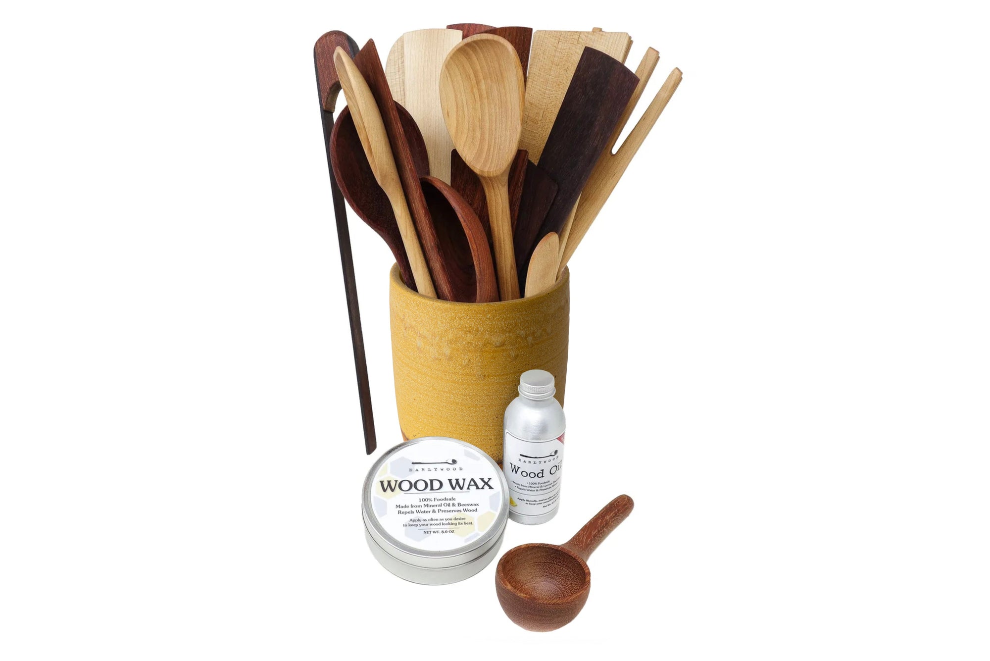 Set of wooden utensils in a holder with wood care products on a white background