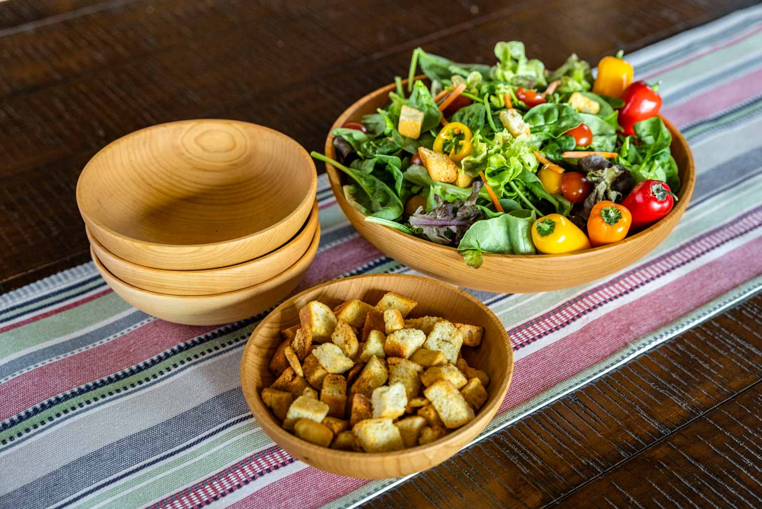 wooden salad bowls on table with runner