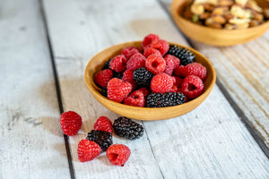 small wooden fruit bowl with berries and nuts