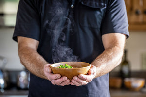 wooden soup bowl with steaming soup