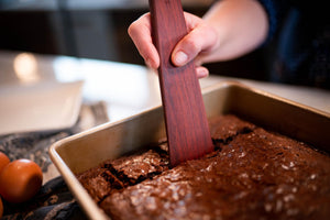 using wooden baking scraper to cut and serve brownies - Earlywood
