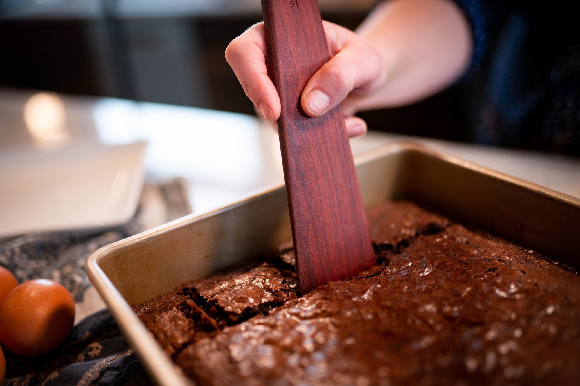 wooden spatula cutting brownies by Earlywood